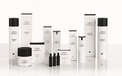 Eine Kollektion von Chris Farrell Haut- und Haarpflegeprodukten in weißen Verpackungen, angeordnet auf einer weißen Fläche.